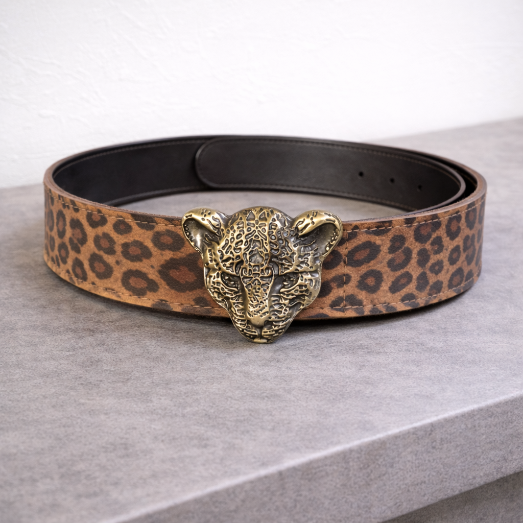 Cinturón de cuero con estampado leopardo y hebilla metálica de pantera sobre superficie gris